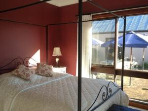 a bedroom with a bed and a window with an umbrella at Greengate Bed and Breakfast in Robertson