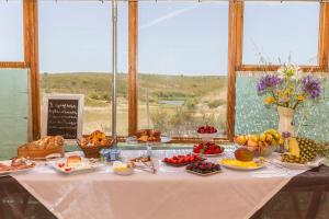 a table with a buffet of fruits and vegetables at Barranco da Fonte in Chabouco