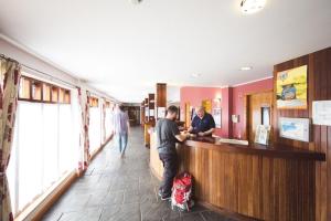 two men are standing at a counter in a store at Bushmills Youth Hostel in Bushmills