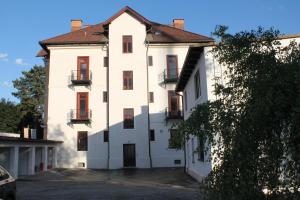 une grande maison blanche avec des fenêtres rouges et une allée. dans l'établissement Murtal Apartments, à Knittelfeld