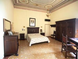 a bedroom with a bed and a table and a desk at Belvilla by OYO Villa Fiorita Tre in Romano D'Ezzelino