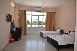 a hotel room with two beds and a window at Thanh Nien Hotel - Vung Tau in Vung Tau