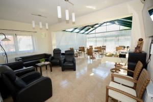 a living room with black furniture and a dining room at Szárszó Panzió in Balatonszárszó