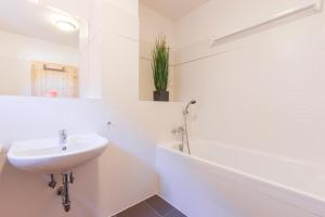 een witte badkamer met een wastafel en een bad bij Chalet6harrachov se saunou in Harrachov