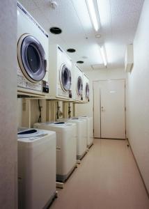 - une rangée de lave-linge et de sèche-linge dans la buanderie dans l'établissement Higashi Hiroshima Green Hotel Morris, à Higashihiroshima