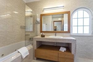 a bathroom with a sink and a shower and a mirror at Villa Amarela in Alvor