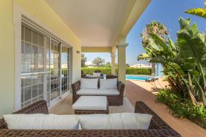 un patio al aire libre con muebles de mimbre y una piscina en Villa Amarela en Alvor