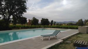 a chair sitting next to a swimming pool at Country House Carmelita in Limigiano