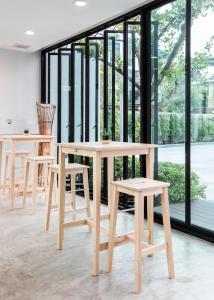 uma mesa e cadeiras num quarto com janelas em NARITA Amata - SHA Plus Certified em Chon Buri