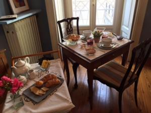 ein Tisch mit einem Teller Brot und Gebäck darauf in der Unterkunft B&B Volta in Como
