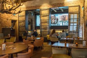 a restaurant with tables and chairs and people sitting at them at Slot Oostende in Goes