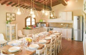 uma grande cozinha com uma mesa longa e cadeiras em Villa Marina - with private panoramic pool em Orciatico