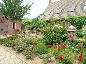 um jardim de flores em frente a uma casa em Bed en Boterham em Hedel