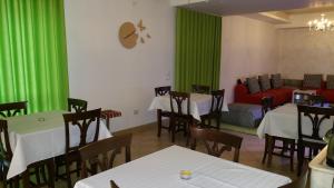 イスピカにあるIl Gheppioの緑のカーテンとテーブル、ソファが備わるレストラン