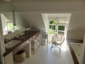 a bathroom with a sink and a chair in it at Chateau des Grotteaux Près Chambord in Chambord