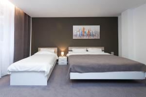 um quarto com duas camas e um quadro na parede em Chess Apartments em Belgrado