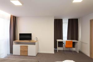 a room with a tv and a desk with a computer at Chess Apartments in Belgrade