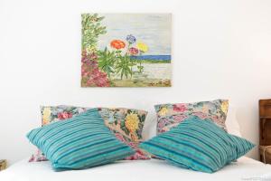 two pillows on a bed with a painting on the wall at Gomes Freire Delight in Cascais