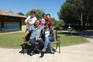 a man and a woman and two children sitting on a chair at Agriturismo Sa Ruda in Càbras