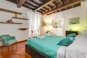 a bedroom with a large bed and a blue chair at Rome as you feel - Panisperna Apartment in Rome