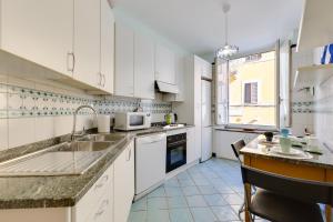 a kitchen with white cabinets and a sink at Rome as you feel - Panisperna Apartment in Rome