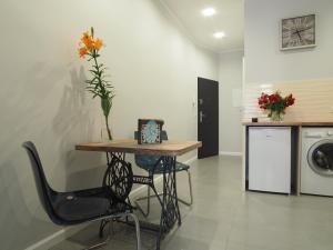 a room with a table with a vase of flowers on it at Grand Tourist Apartment Merlin in Gdańsk