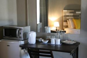a room with a table with a microwave and a bed at Lallapanzi Country Stay in Ermelo