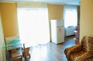 - un salon avec un réfrigérateur et une table dans l'établissement Apartments on Svobody 39, à Oujhorod