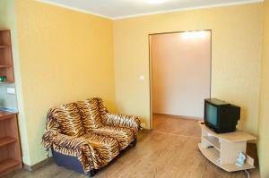 Habitación con TV y silla con estampado de cebra. en Apartments on Svobody 39, en Uzhhorod