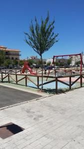 un parque con un parque infantil con un árbol en Tabano, en Chipiona