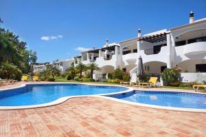 a swimming pool in front of a large building at Palmeira VIP Apartment in Portimão