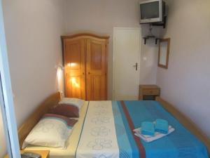 ein Schlafzimmer mit einem Bett mit 2 Handtüchern und einem TV in der Unterkunft Apartments Morgen in Brna