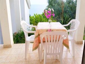 a white table with chairs and a vase of flowers on a patio at Paradiso Apartments - Liman1 in Ulcinj