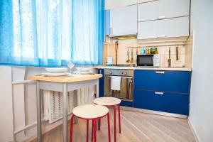 モスクワにあるLuxApartments-Проспект Мираのキッチン(青いキャビネット、スツール2脚付)