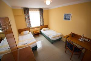 Zimmer mit 2 Betten, einem Tisch und einem Schreibtisch in der Unterkunft Landhaus Havelse in Garbsen