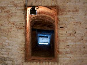 a window in a brick wall with a light at Palacio Rejadorada in Toro