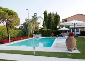 a swimming pool in a yard with a large vase at Villa Orange in Pescantina