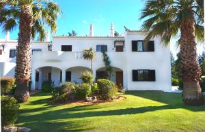 een wit huis met palmbomen in de tuin bij Palmeira VIP Apartment in Portimão