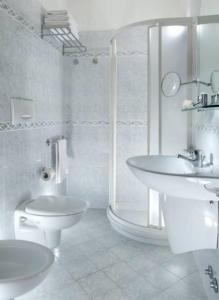 ein Badezimmer mit zwei Waschbecken, einer Dusche und einem WC in der Unterkunft Hotel Ambra in Rimini