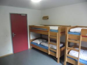 a room with three bunk beds and a red door at DJH Jugendherberge Mannheim International in Mannheim