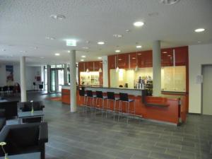 a lobby with chairs and a bar in a cafeteria at DJH Jugendherberge Mannheim International in Mannheim