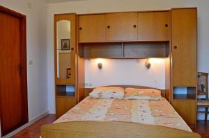 a bedroom with a large bed with a wooden headboard at Apartmani Peko in Pag