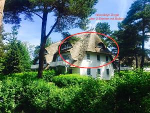 a house with a thatched roof with a red circle around it at Maisonette-Fewo unter Reet, 50m zum Meer, Strandidyll Zingst in Zingst