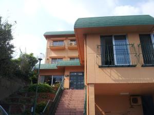 um edifício com uma escada ao lado de um edifício em Orange Pension em Gamagori