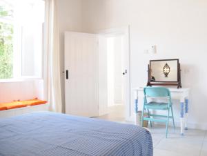 1 dormitorio con cama, escritorio y silla azul en The Stable en Limassol