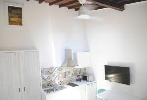 a kitchen with white cabinets and a flat screen tv at The Stable in Limassol