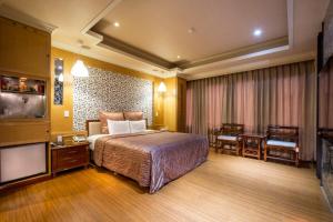 a hotel room with a bed and a flat screen tv at Ching Ching Motel in Sanxia