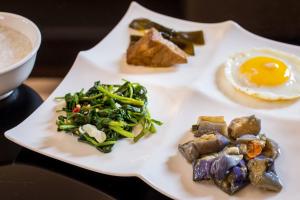 a plate of food with an egg on a table at Ching Ching Motel in Sanxia