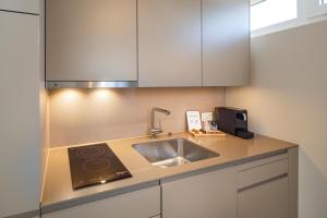 a kitchen with a sink and white cabinets at welcome homes in Glattbrugg