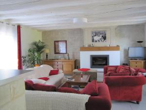 sala de estar con 2 sofás y chimenea en AU GRÉ DE LALOIRE en Bréhémont